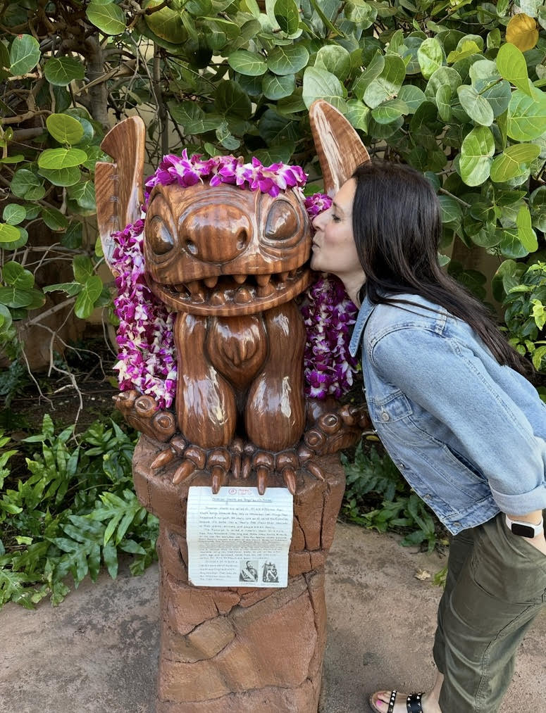 Deborah kissing a Stitch tiki statue at Aulani