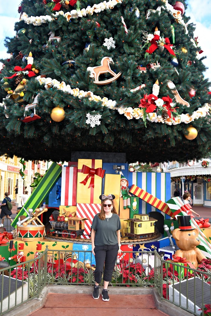 Heather in front of the Magic Kingdom Christmas tree