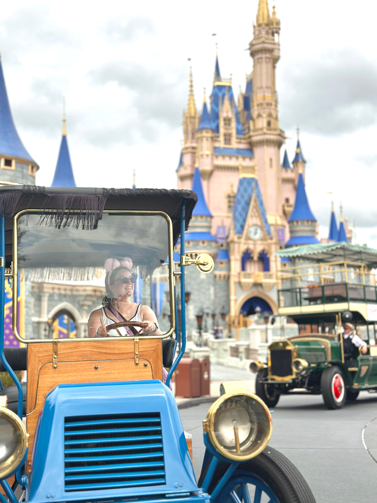 Kathryn driving a Main Street vehicle with Cinderella Castle behind her
