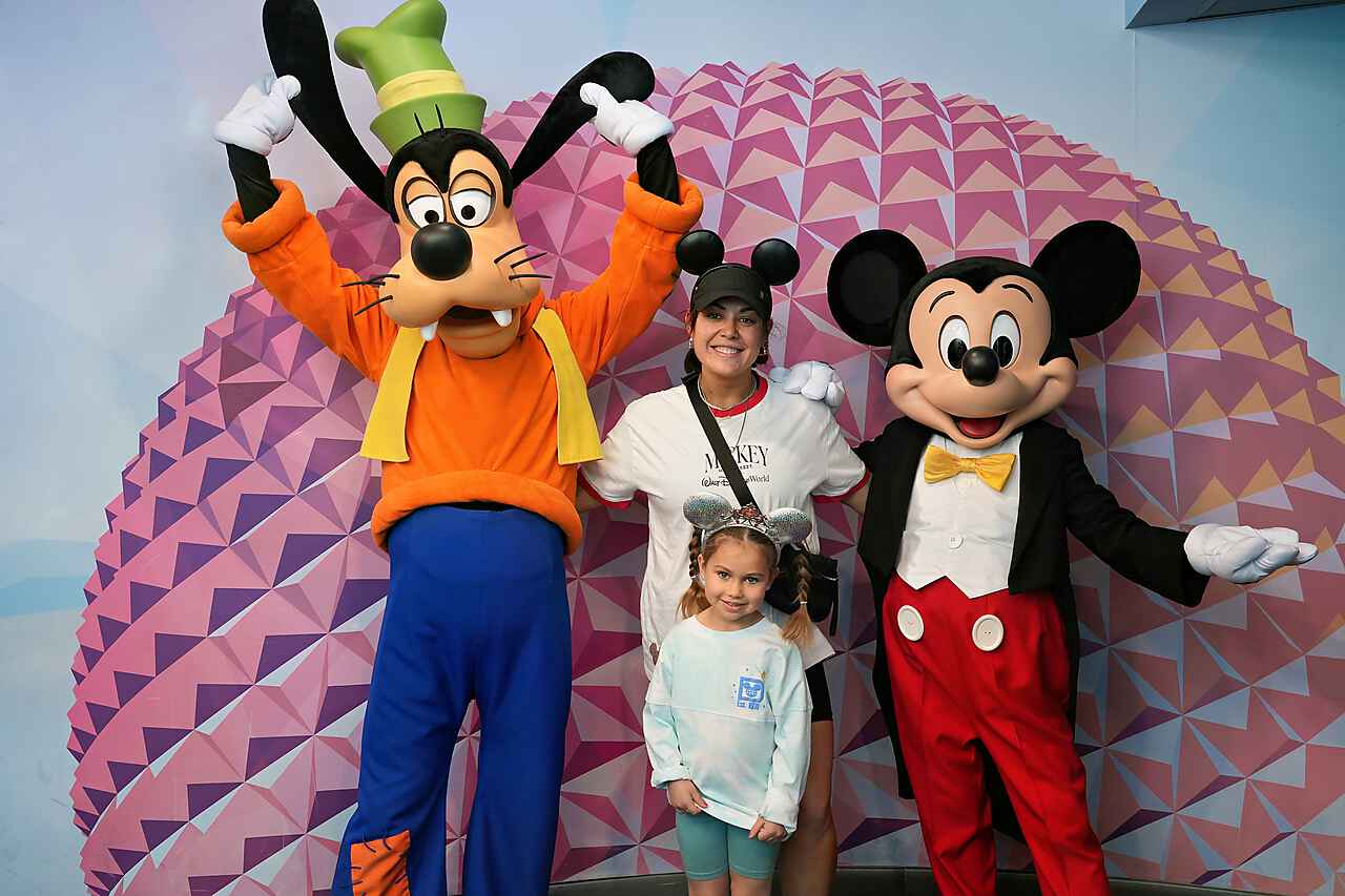 Giselle and her daughter with Mickey Mouse and Goofy at EPCOT's Spaceship Earth