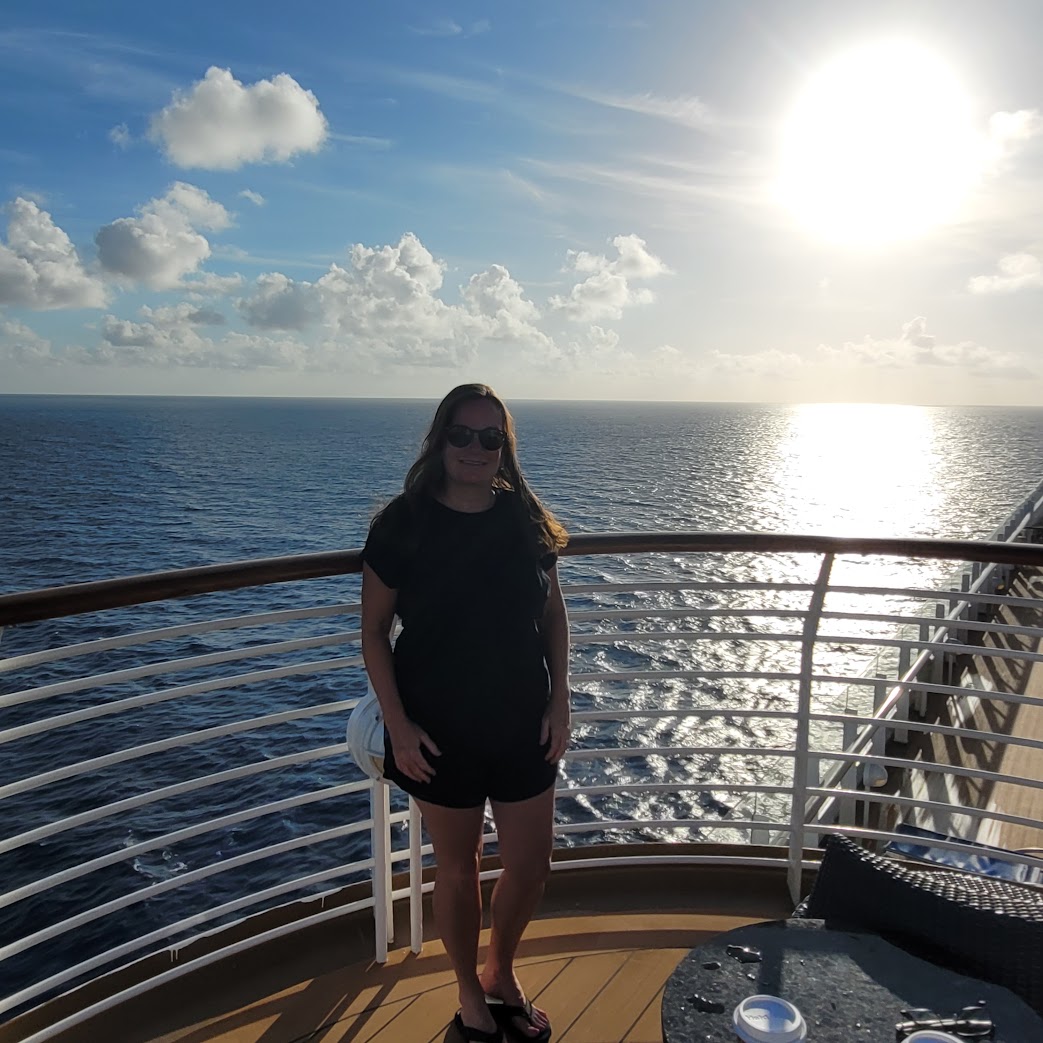 Heather watching the sunrise from a Disney cruise ship deck