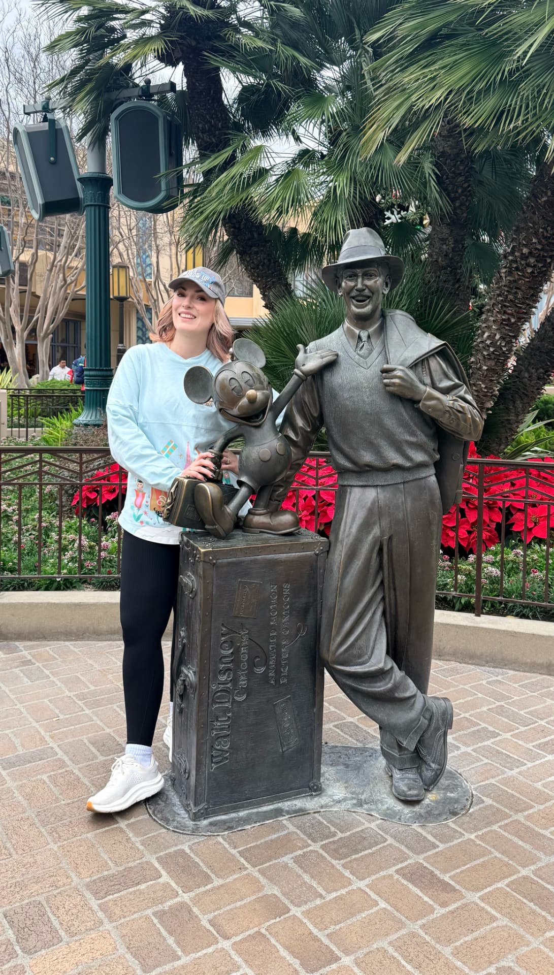 Jenn Lee posing with the Storytellers statue at Disney California Adventure Park